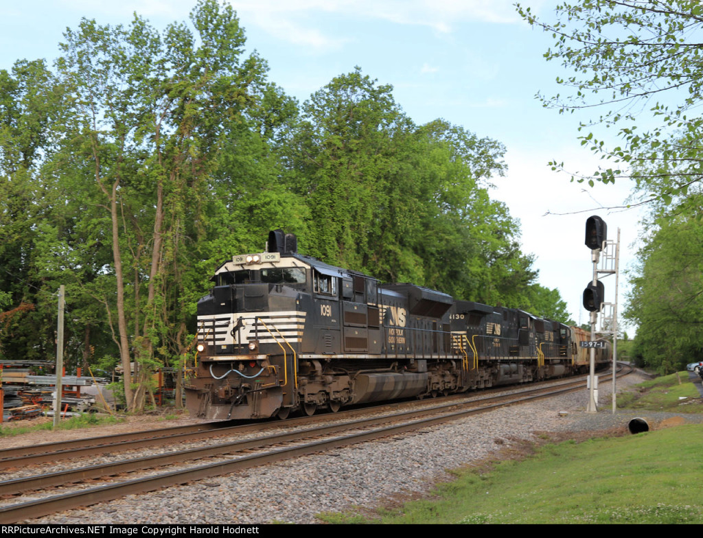 NS 1091 leads train 62U past the signals at "waffle House" early in the morning